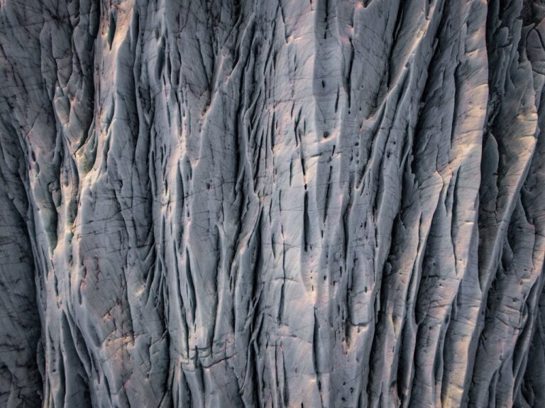 A detailed aerial view of a rugged rock surface with natural erosion patterns in Iceland.